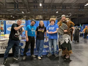 Cosplayers and creators at Fleetwood Community Comic Con booth showcasing fantasy comics and Viking cosplay
